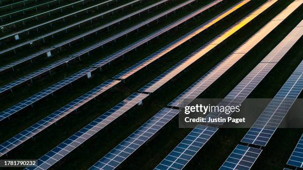 drone view over a field of solar panels at sunset - sky bar stock pictures, royalty-free photos & images