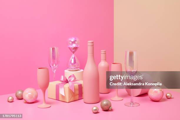 abstract pastel colored 3d scene with pink and beige background, wine bottles,  champagne glasses, sparkling hourglass, christmas gifts and ornaments. - champange bottle and valentines day stock pictures, royalty-free photos & images