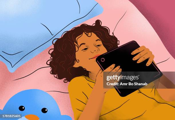 view from above happy girl laying, using digital tablet on bed at home - social media stock illustrations