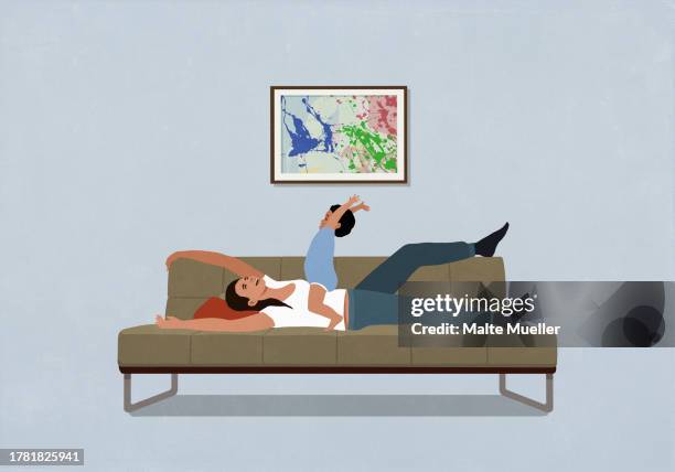 happy, playful mother and baby son on living room sofa at home - familie sofa stock-grafiken, -clipart, -cartoons und -symbole