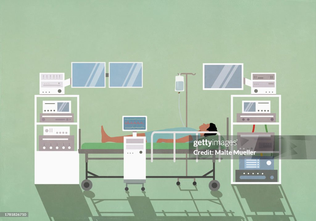 Male patient laying on operating table among technology equipment in operating room
