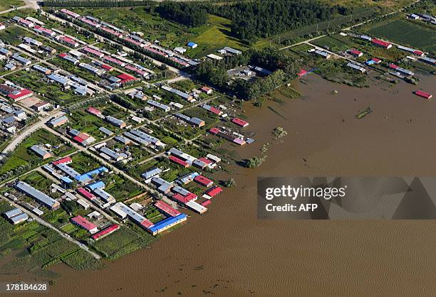 This aerial view picture taken on August 26, 2013 shows houses submerged by the flooded Heilongjiang River, called the Amur River in Russia, in...