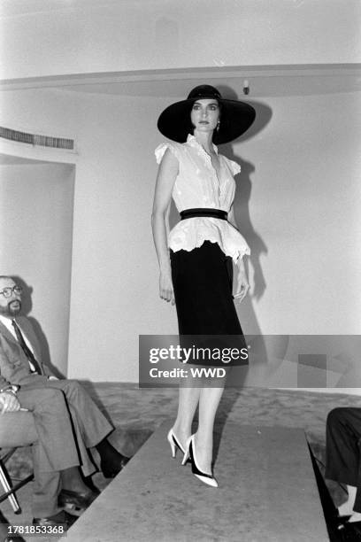 Model Margaret Donohoe presents an ensemble from the spring 1985 ready to wear collection inside of designer Pauline Trigère's New York City showroom.