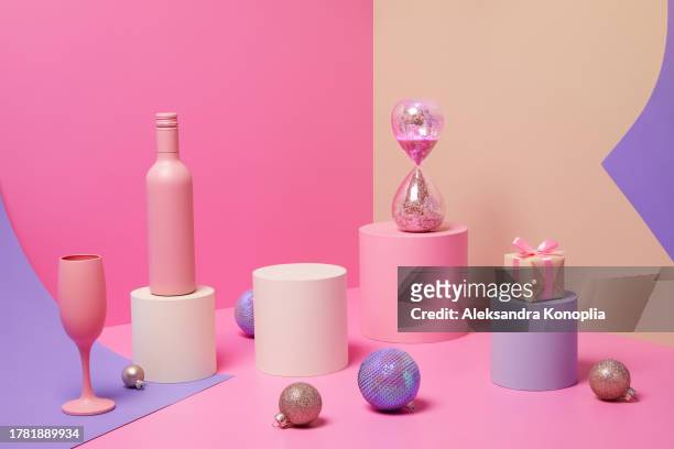 abstract pastel colored 3d scene with pink, beige and lavender purple background, empty podium, wine bottle,  champagne glasses, sparkling hourglass, christmas gifts and ornaments - 砂時計　無人 ストックフォトと画像