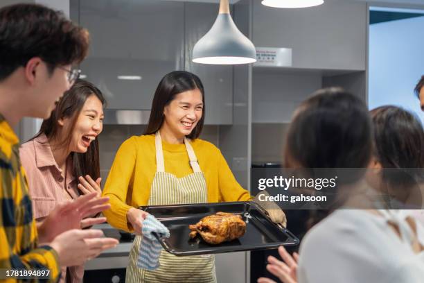 cheerful woman serving delicious food to friends - service of thanksgiving stock pictures, royalty-free photos & images