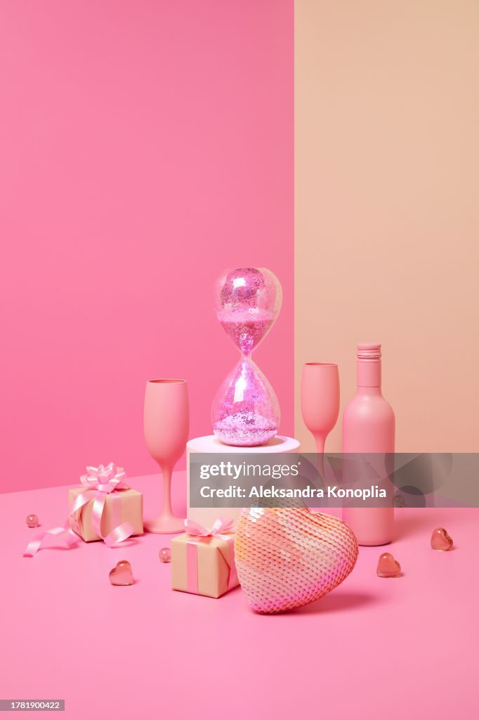 Abstract pastel colored 3d scene with pink and beige background, wine bottles, champagne glasses, sparkling hourglass, Christmas gifts and heart ornaments.
