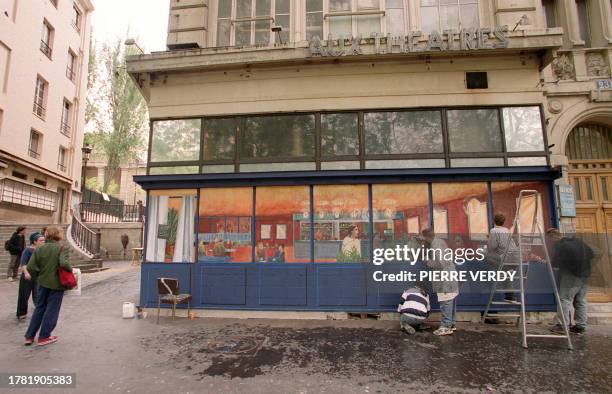 Des étudiants du lycée Duperré peignent, le 19 mai 1999 à Paris, un café en trompe l'oeil sur une boutique à l'abandon sur les Grands Boulevards...