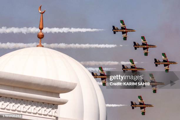 Aermacchi MB-339 trainer aircraft of the Fursan al-Emarat aerobatics team release smoke as they fly over during the 2023 Dubai Airshow at Dubai World...