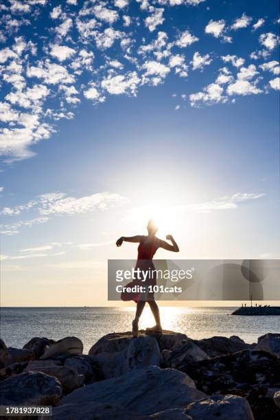 ballerina dancing on rocks in a cloudy day. - glamour live show fashion shows stock pictures, royalty-free photos & images