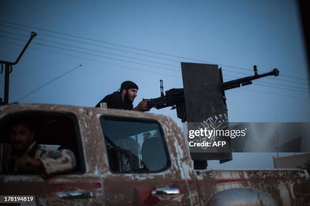 Member of the Islamist Syrian opposition group Ahrar al-Sham fires against a position of the Committees for the Protection of the Kurdish People , a...