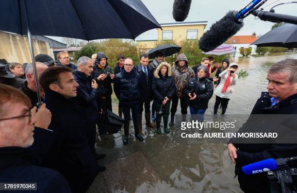 France's President Emmanuel Macron , flanked by French Agriculture Minister Marc Fesneau , talks to a resident during a visit in Le Doulac near...