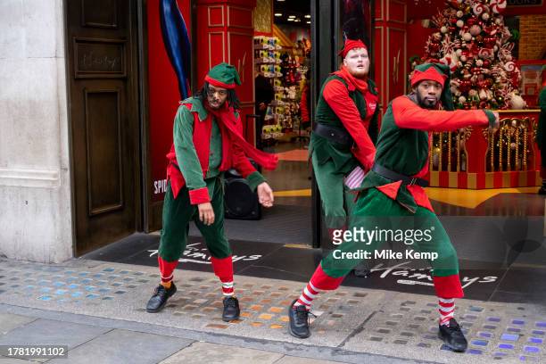 Entertainers perform a Christmas elves song and dance routine for shoppers outside toy shop Hameys on Regent Street on 13th November 2023 in London,...
