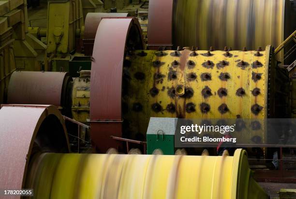 An employee stands between giant rotating drums used for the processing of potash at the chemical enrichment plant operated by OAO Uralkali in...