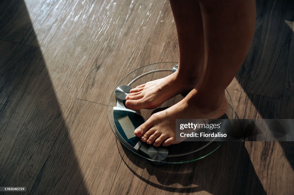 A woman standing in the morning on the scales