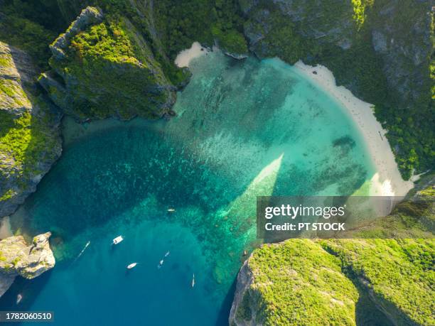 aerial view andaman sea in a bay with a beach surrounded by green mountains at phi phi island, maya bay, krabi, thailand - provincia-di-phuket foto e immagini stock