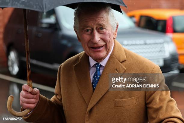 Britain's King Charles III reacts as he arrives to attend the launch of "The Coronation Food Project" to mark his majesty's 75th birthday, during a...