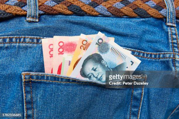 chinese curency in pocket - money talks refrán en inglés fotografías e imágenes de stock