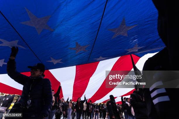 Members of Wounded Wariors Project march with huge American Flag during 104th annual Veterans Day Parade on 5th Avenue.