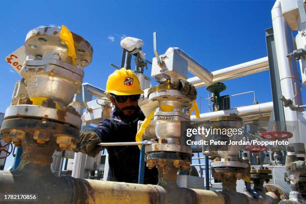 Construction worker, wearing a Bechtel Corporation hard hat, works on pipework valves during construction of the Maghreb-Europe Gas Pipeline in the...