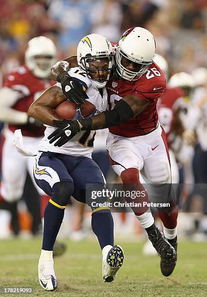 Wide receiver Robert Meachem of the San Diego Chargers is tackled by defensive back Curtis Taylor of the Arizona Cardinals during the preseason NFL...