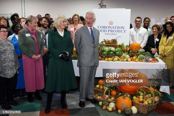 Britain's King Charles III and Britain's Queen Camilla pose of pictures with members of staff during the launch of "The Coronation Food Project", to...