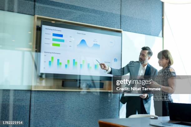 enhance credibility and trust in face-to-face communication to build powerful relationships. business executive in a board room discussing a business project over info-graphic data on a screen in a business office. - risikomanagement stock-fotos und bilder