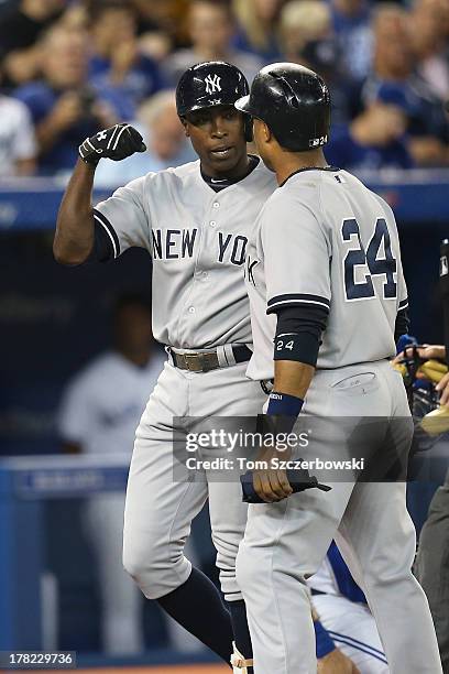 Alfonso Soriano of the New York Yankees celebrates his three-run home run in the first inning with Robinson Cano during MLB game action against the...