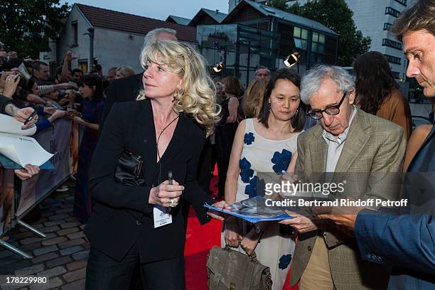 Director Woody Allen signs an autograph to Stephane Celerier, CEO of Mars Distribution , as Allen's wife Soon-Yi Previn looks on, as they arrive to...
