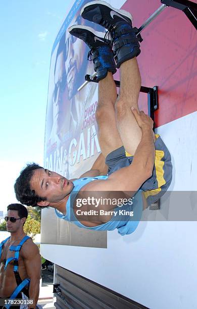 Live body builders work out on a billboard over Sunset Boulevard celebrating the Blu-Ray/DVD release of 'Pain & Gain' on August 27, 2013 in West...