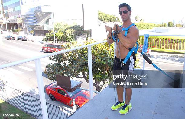 Live body builders work out on a billboard over Sunset Boulevard celebrating the Blu-Ray/DVD release of 'Pain & Gain' on August 27, 2013 in West...