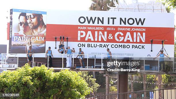 Live body builders work out on a billboard over Sunset Boulevard celebrating the Blu-Ray/DVD release of 'Pain & Gain' on August 27, 2013 in West...