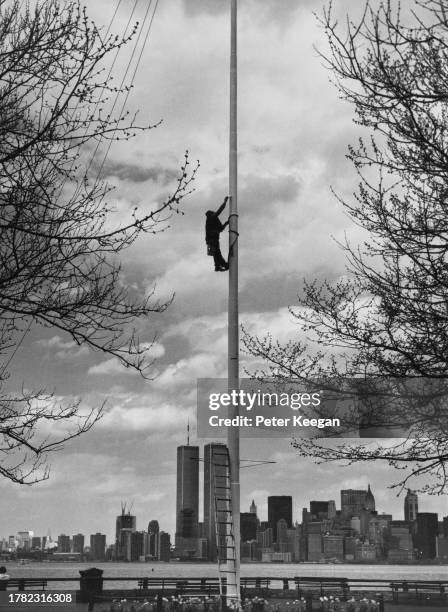 Painter repainting a flagpole during renovations ahead of the Statue of Liberty's 100th anniversary, on Liberty Island, in Upper New York Bay, New...