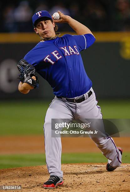 Starting pitcher Derek Holland of the Texas Rangers pitches against the Seattle Mariners at Safeco Field on August 27, 2013 in Seattle, Washington.