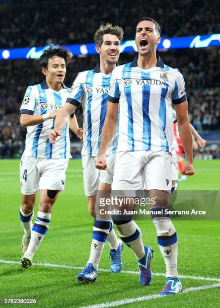 Mikel Merino of Real Sociedad celebrates with teammates Takefusa Kubo and Aritz Elustondo after scoring the team's first goal during the UEFA...