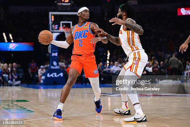 Shai Gilgeous-Alexander of the Oklahoma City Thunder handles the ball while being defended by Saddiq Bey of the Atlanta Hawks during the first half...