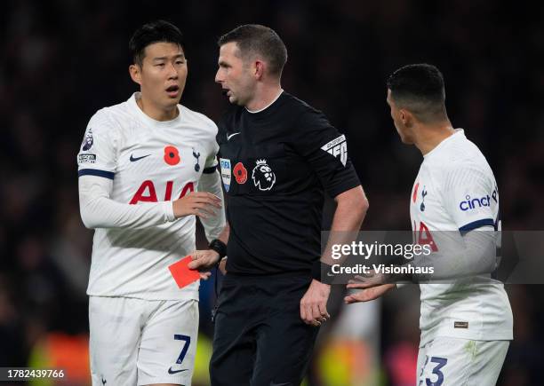 Heung-Min Son and Pedro Porro of Tottenham Hotspur and referee Michael Oliver after Oliver has sent off Cristian Romero during the Premier League...