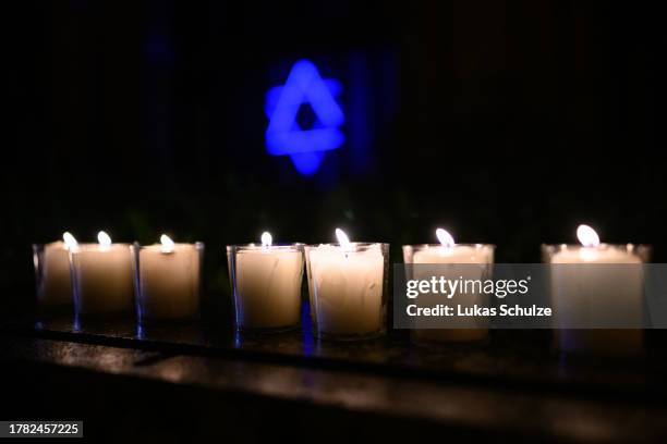 Candles and The Star of David are seen at the Synagogue of Cologne while people walk in a silent march through the city center to commemorate the...