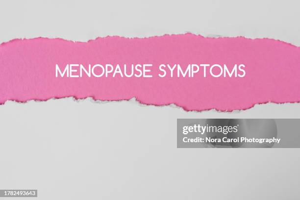 menopause symptoms texts on pink torn paper - symptom stock pictures, royalty-free photos & images