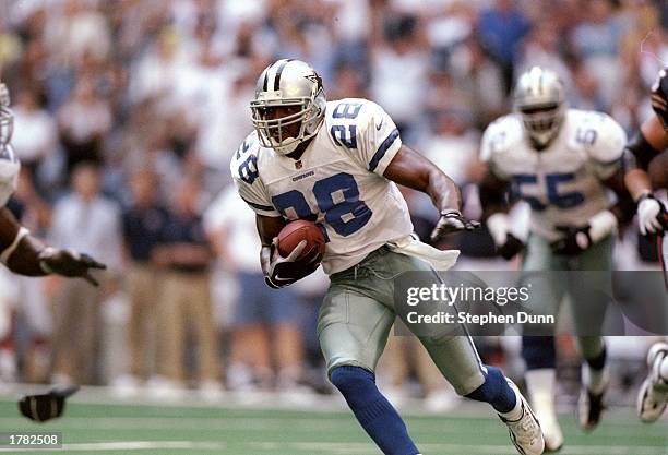 Defensive back Darren Woodson of the Dallas Cowboys carries the football after an interception during the Cowboys 27-3 win over the Chicago Bears at...