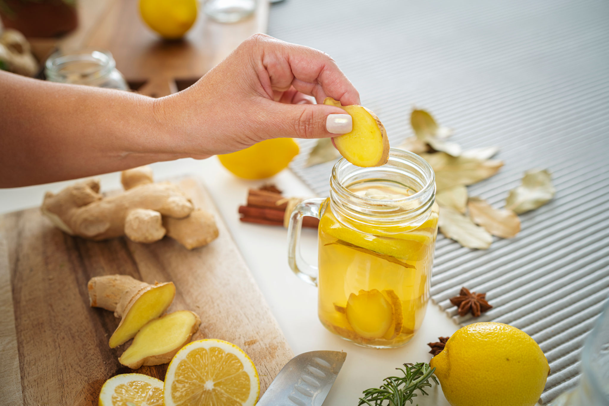 High angle view of woman preparing ginger and lemon infused water High angle view of woman preparing ginger and lemon infused water