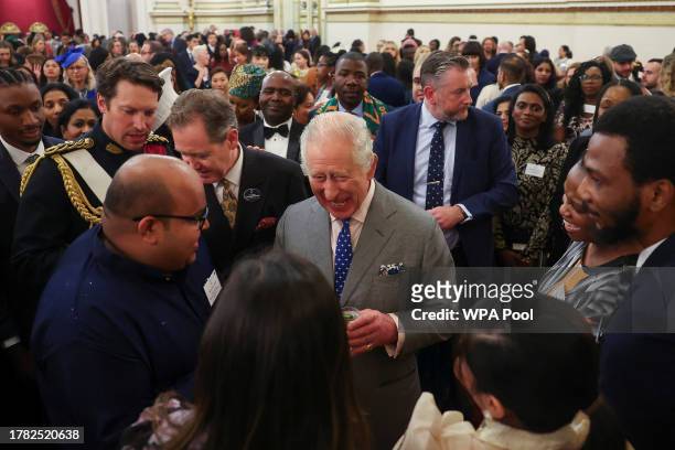 Britain's King Charles III speaks with guests as he meets nurses and midwives to celebrate their work at Buckingham Palace on November 14, 2023 in...
