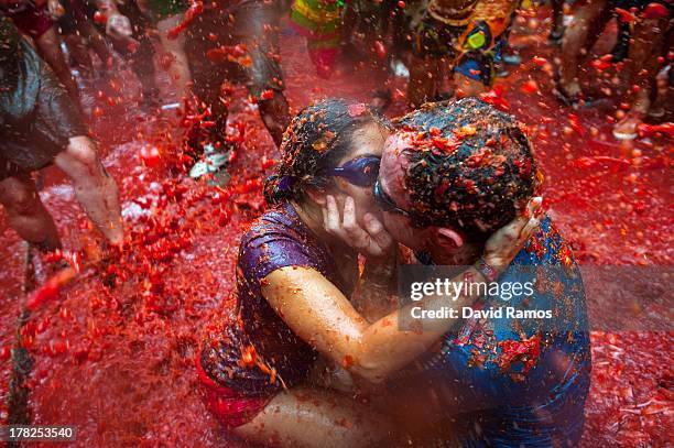 Two Revellers kiss each other covered in tomato pulp while participating the annual Tomatina festival on August 28, 2013 in Bunol, Spain. An...