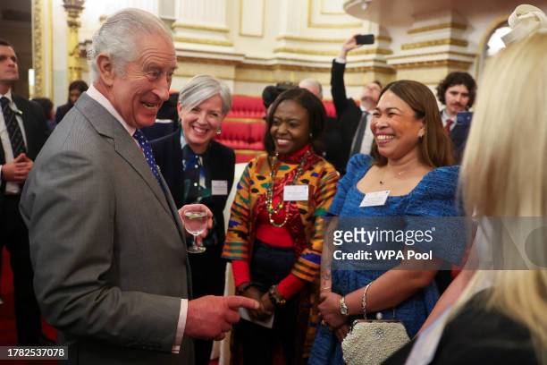 Britain's King Charles III greets guests as he meets nurses and midwives to celebrate their work at Buckingham Palace on November 14, 2023 in London,...