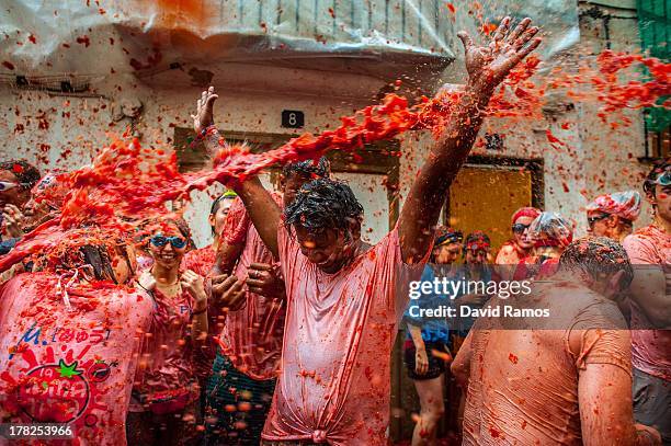 Revellers celebrate covered by tomato pulp while participating the annual Tomatina festival on August 28, 2013 in Bunol, Spain. An estimated 20,000...