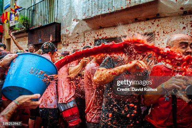 Revellers celebrate covered by tomato pulp while participating the annual Tomatina festival on August 28, 2013 in Bunol, Spain. An estimated 20,000...