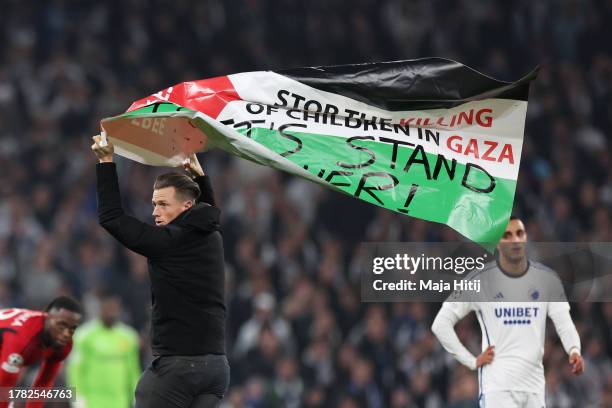 Pitch invader holds the Palestinian flag during the UEFA Champions League match between F.C. Copenhagen and Manchester United at Parken Stadium on...