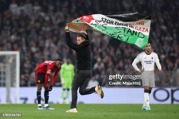 Pitch invader holds the Palestinian flag during the UEFA Champions League match between F.C. Copenhagen and Manchester United at Parken Stadium on...