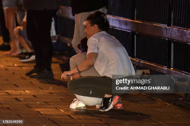 People take cover as warning sirens sound of an incoming rocket attack from the Gaza Strip, on November 14, 2023 in Jaffa, amid the ongoing battles...