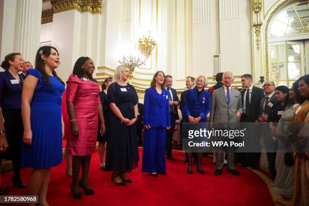 Britain's King Charles III listens as members of the NHS Choir sing during a meeting with nurses and midwives to celebrate their work at Buckingham...