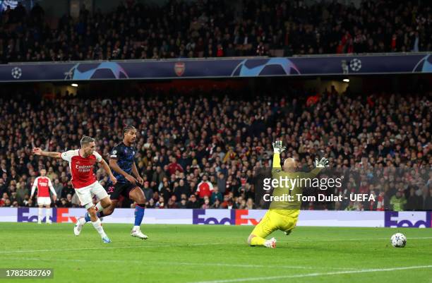 Leandro Trossard of Arsenal scores the team's first goal past Marko Dmitrovic of Sevilla FC during the UEFA Champions League match between Arsenal FC...